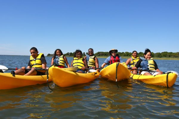 Multicultural youth float on kayaks as part of the Center for Aquatic Sciences youth engagement program.