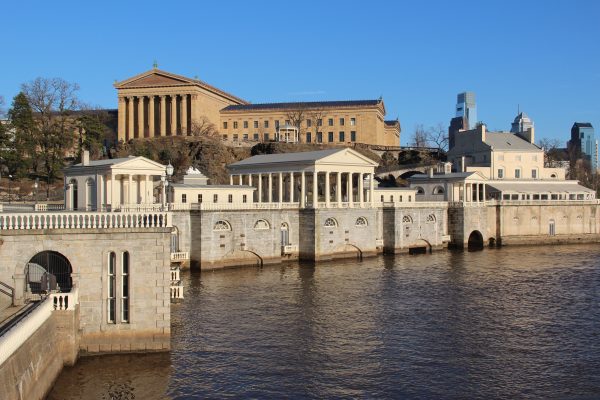 A view of the historic Fairmount Water Works in Philadelphia, with the Philadelphia Art Museum and partial city skyline in the background, and the Schuylkill River in the front.